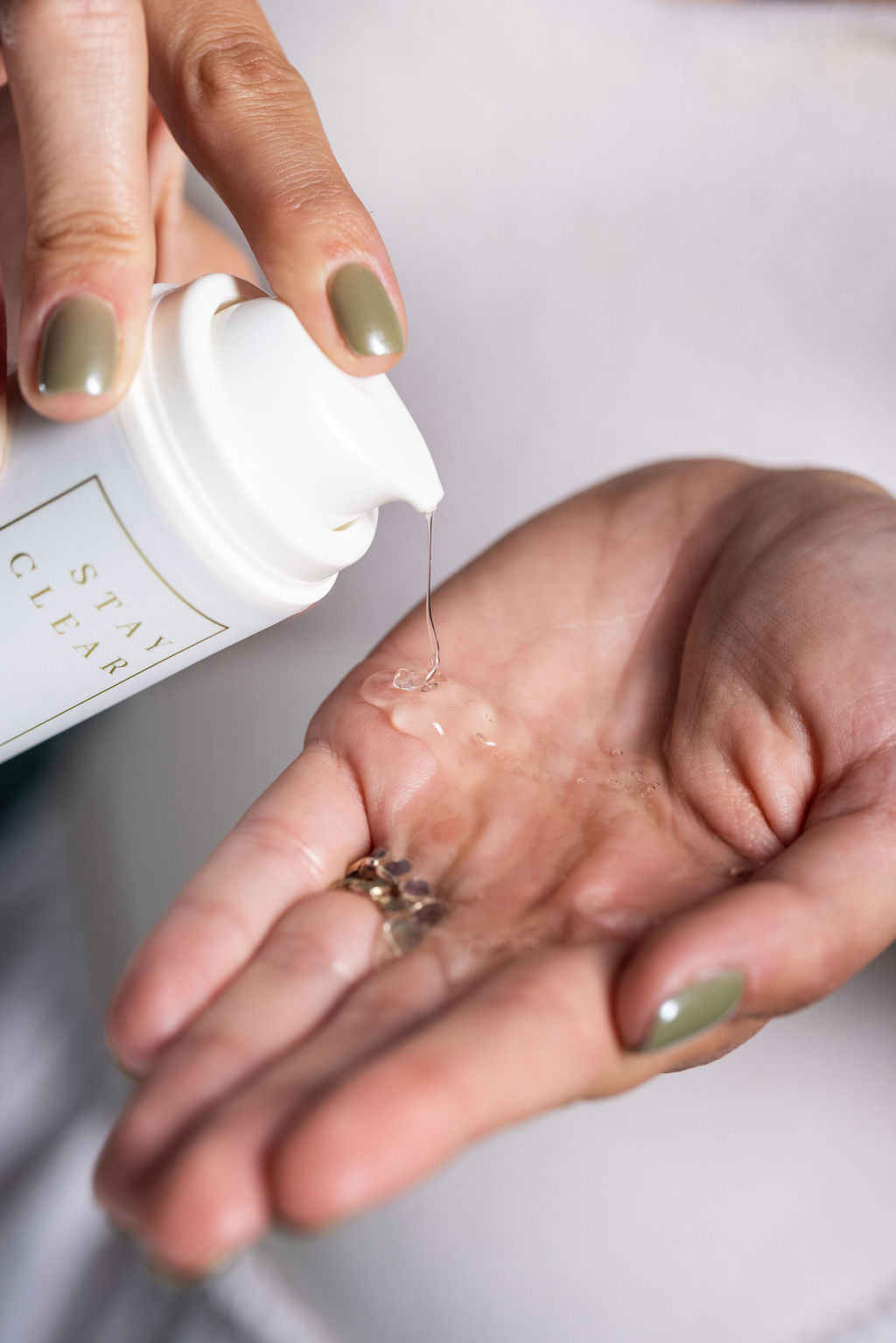 A person dispensing Stay Clear Flawless Start Gel Cleanser onto their hand, preparing to cleanse their face for a refreshed and clear complexion.