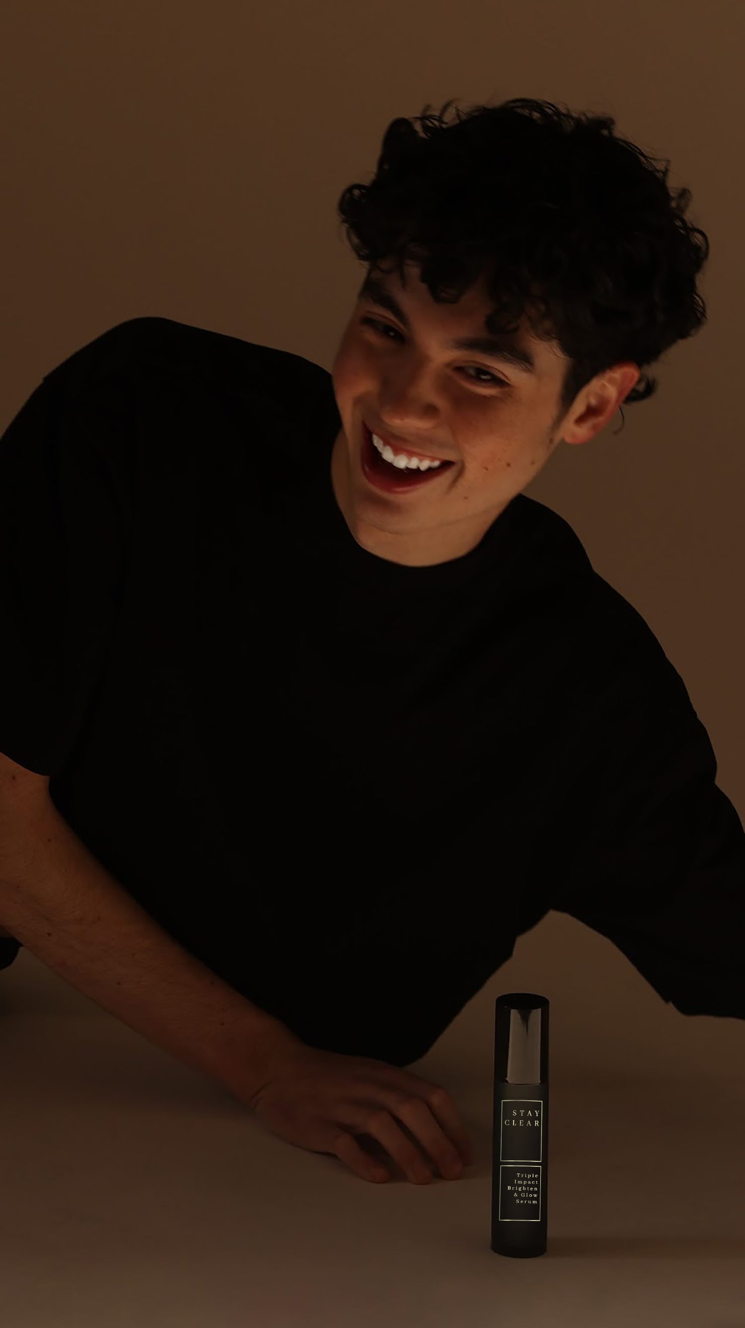  man holding Stay Clear Triple Impact Brighten & Glow Serum, highlighting its advanced formula designed to brighten, even skin tone, and enhance radiance for a luminous complexion.