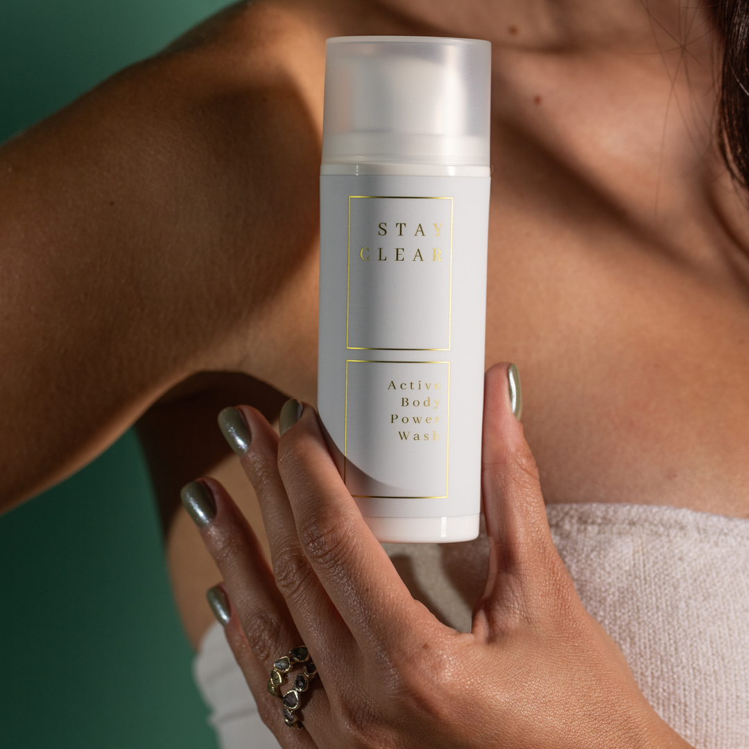 A woman holding Stay Clear Active Body Wash, highlighting its invigorating formula designed to deeply cleanse and refresh the skin after intense physical activity.