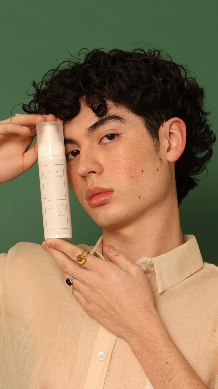 Man holding Stay Clear Beauty Enduring Radiance Lactic Toner next to his face — lactic acid toner for brightening, gentle exfoliation, uneven skin tone, and sensitive acne-prone skin.