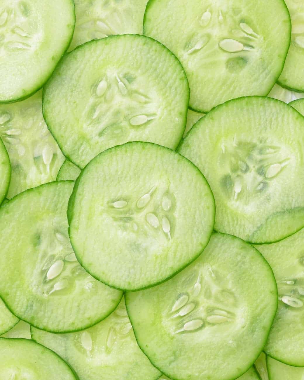 Sliced cucumbers with Stay Clear Beauty Enduring Radiance Lactic Toner — lactic acid toner lightly scented with fresh cucumber for brightening, gentle exfoliation, and sensitive acne-prone skin.