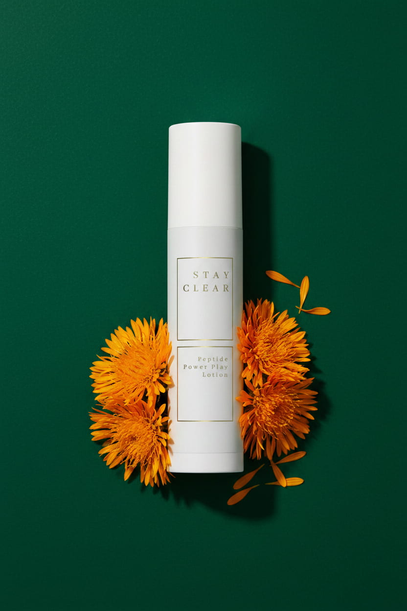 Stay Clear Beauty Peptide Power Play Lotion bottle with safflower blooms on forest green background — copper peptide lotion with Carthamus Tinctorius Seed Oil for skin repair and hydration