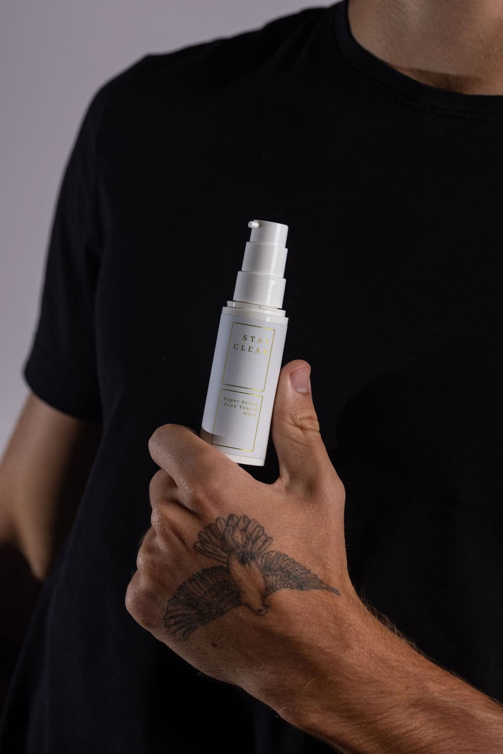 Man holding Stay Clear Beauty Super Serum Even Tone & Glow Sensitive — brightening serum for dark spots, post-acne marks, and uneven skin tone on dry and sensitive skin.
