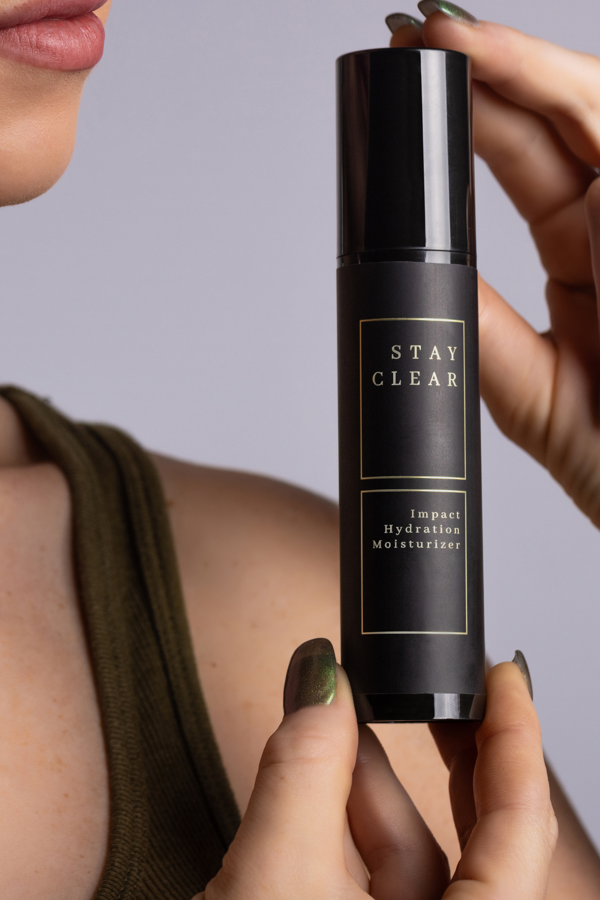 A woman holding Stay Clear Impact Hydration Moisturizer, highlighting its advanced formula designed to deeply hydrate and nourish the skin for a supple, radiant complexion.