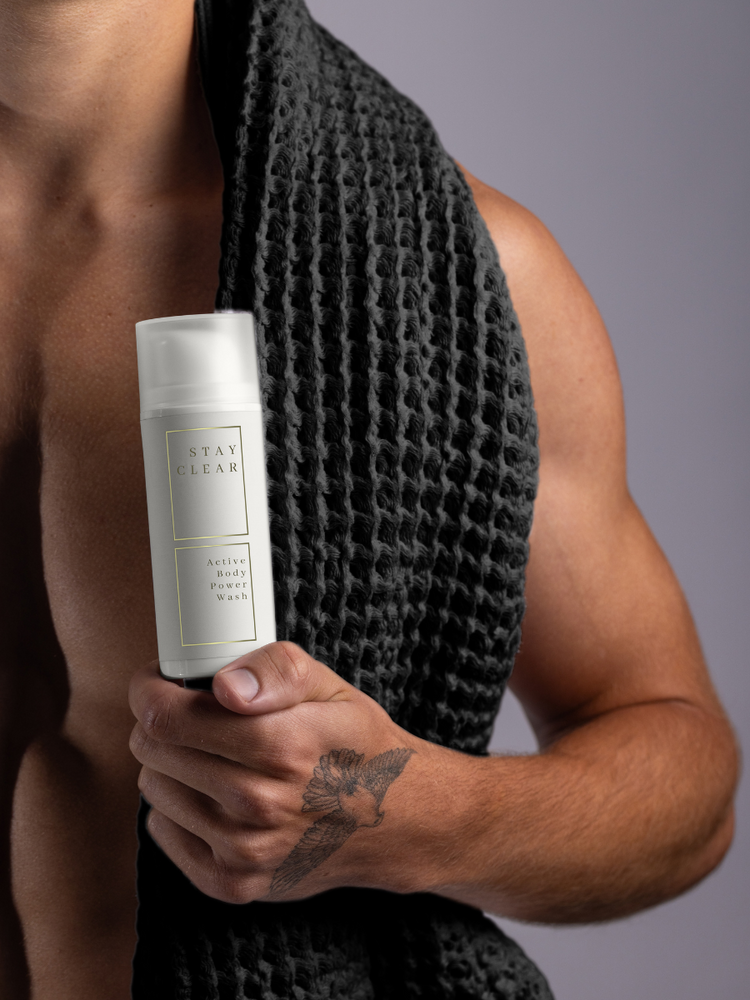 A man holding Stay Clear Active Body Wash, emphasizing its invigorating formula designed to deeply cleanse and refresh the skin after intense physical activity.