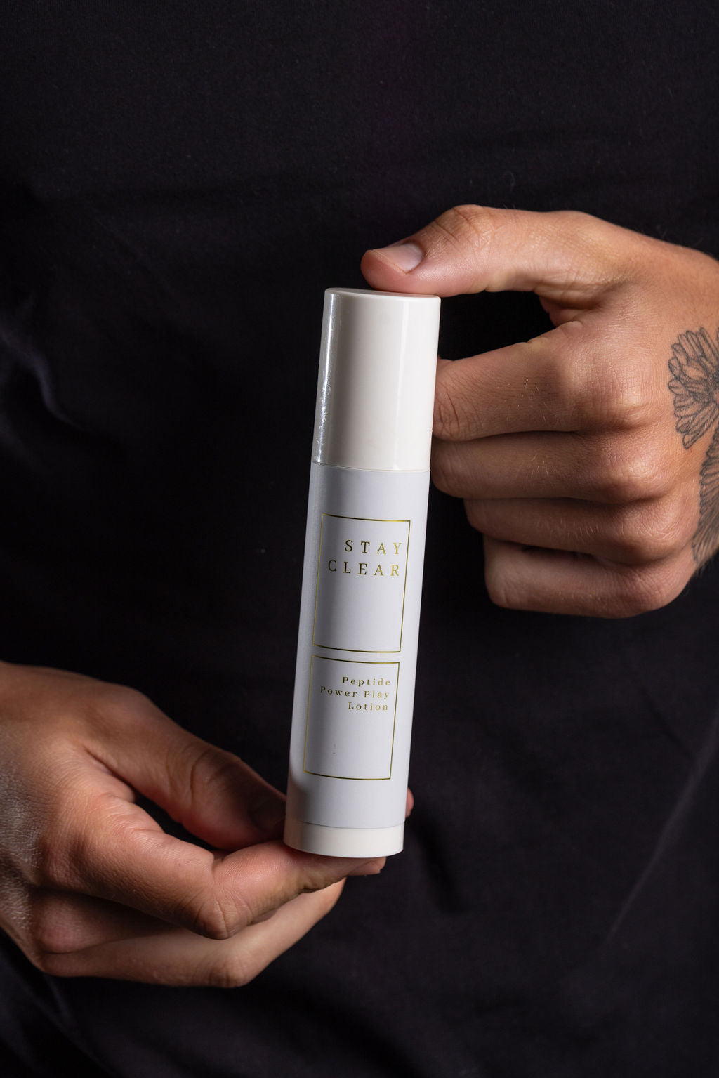 A man holding Stay Clear lotion, highlighting its deeply hydrating and soothing formula designed to protect dry, sensitive skin in extreme climates.
