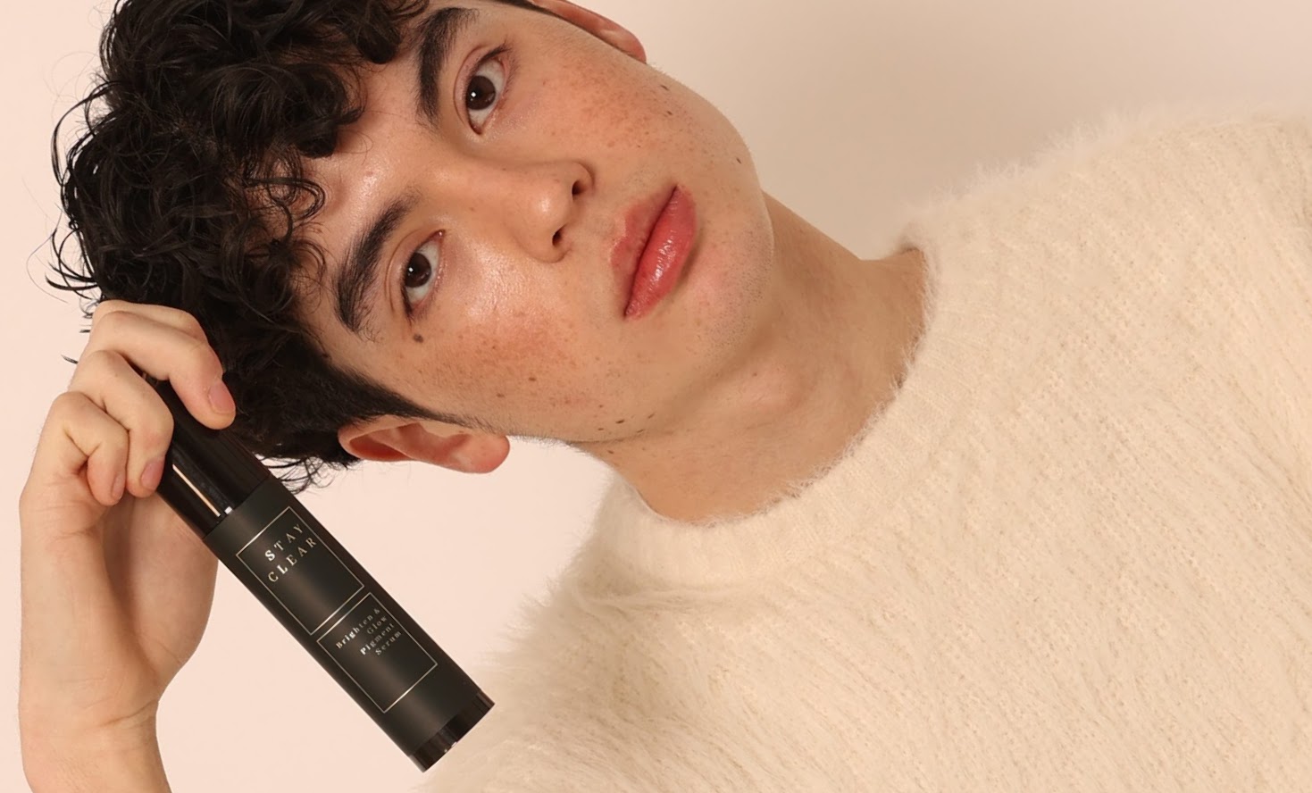 A man holding Stay Clear Triple Impact Brighten & Glow Serum, highlighting its advanced formula designed to brighten, even skin tone, and enhance radiance for a luminous complexion.