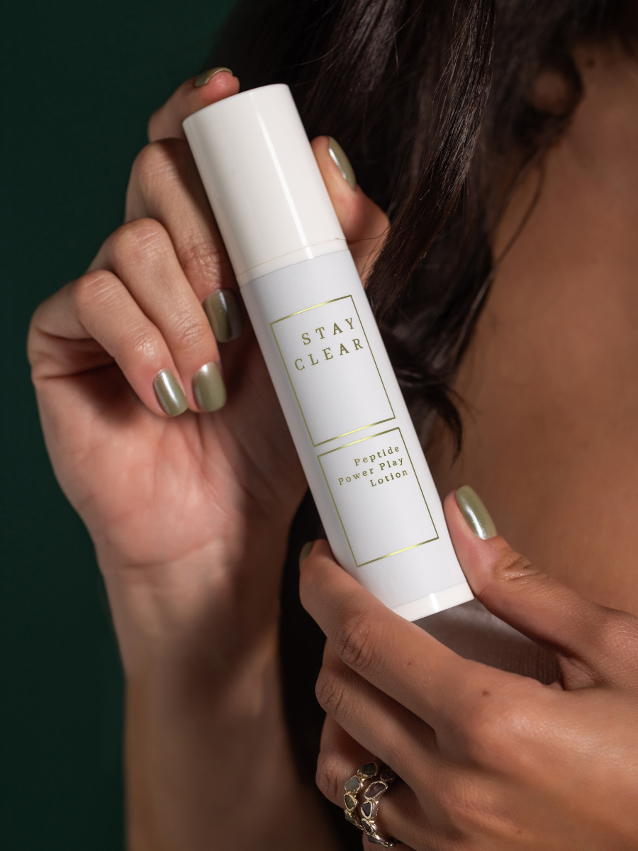 A woman holding Stay Clear Peptide Power Play Lotion, highlighting its peptide-rich formula designed to enhance skin firmness, reduce fine lines, and provide deep hydration for a youthful complexion.