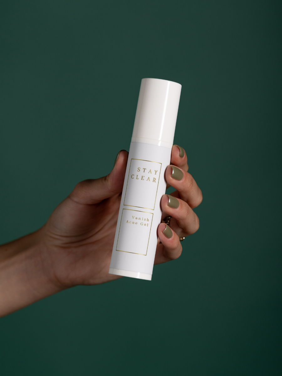 A woman holding Stay Clear Vanish Acne Gel, featuring its benzoyl peroxide formula designed to effectively treat and prevent acne breakouts for clearer skin.