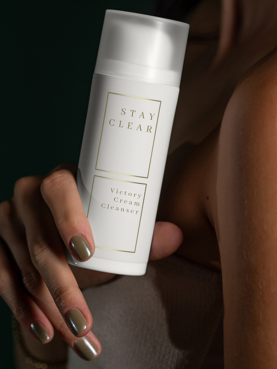 A woman’s hands holding the Stay Clear Victory Cream Cleanser, highlighting its rich, nourishing formula designed to gently cleanse and support normal to combination skin.