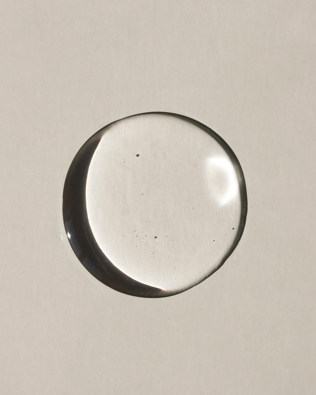 A pump of Stay Clear Beauty Triple Impact Brighten & Glow Serum on a flat surface, showing its lightweight, clear serum texture.